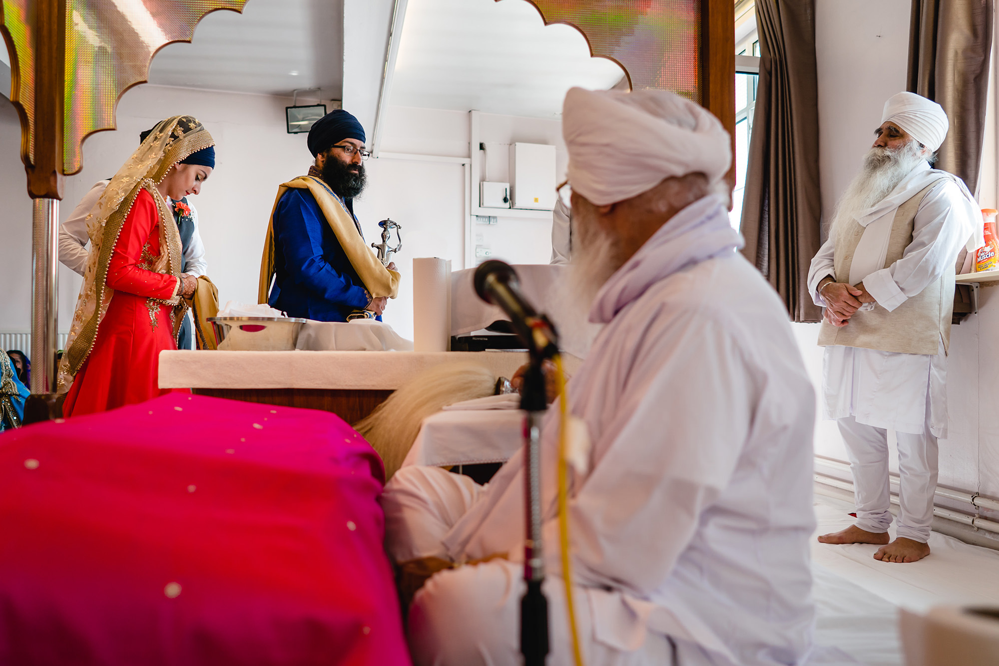 bride and groom walking around the sikh holy book
