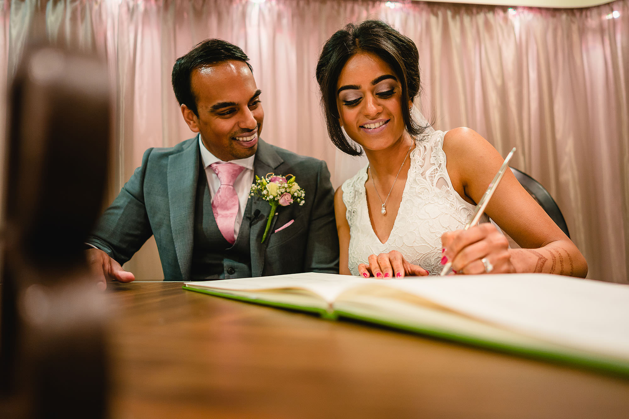 bride and groom signing the registrar